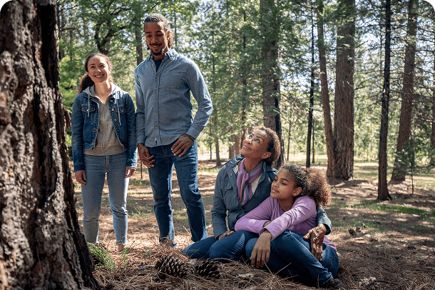 Family gathered around a memorial tree in a protected forest, honoring a loved one and celebrating life’s ongoing connection to nature.